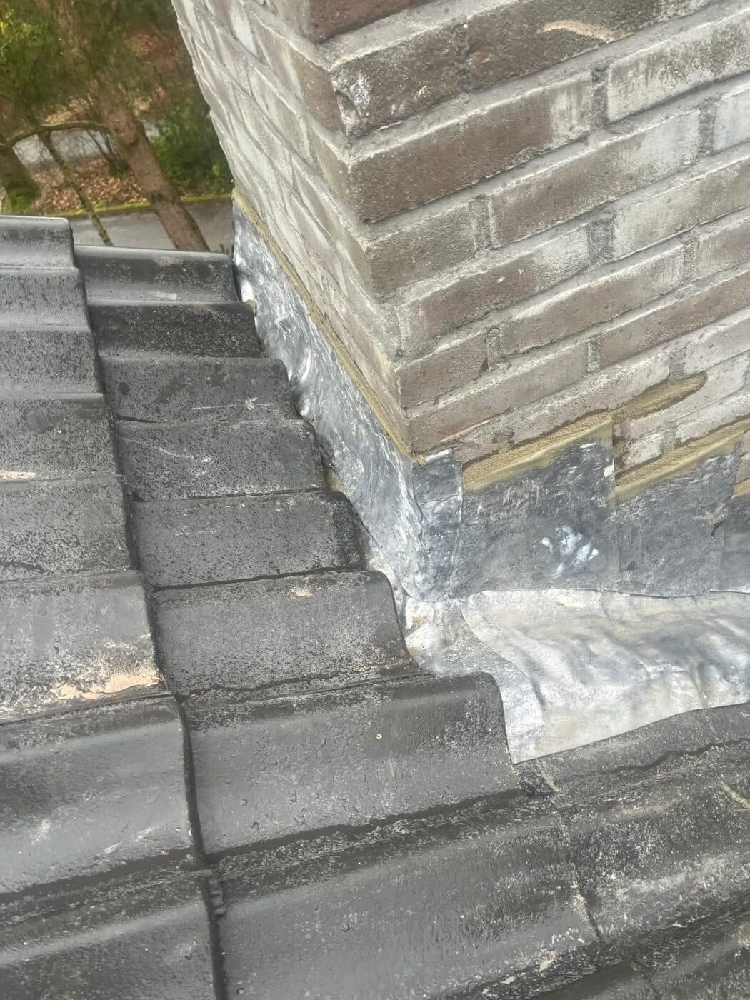 Loodwerk rond een schoorsteen, waterdicht ingewerkt op een dak