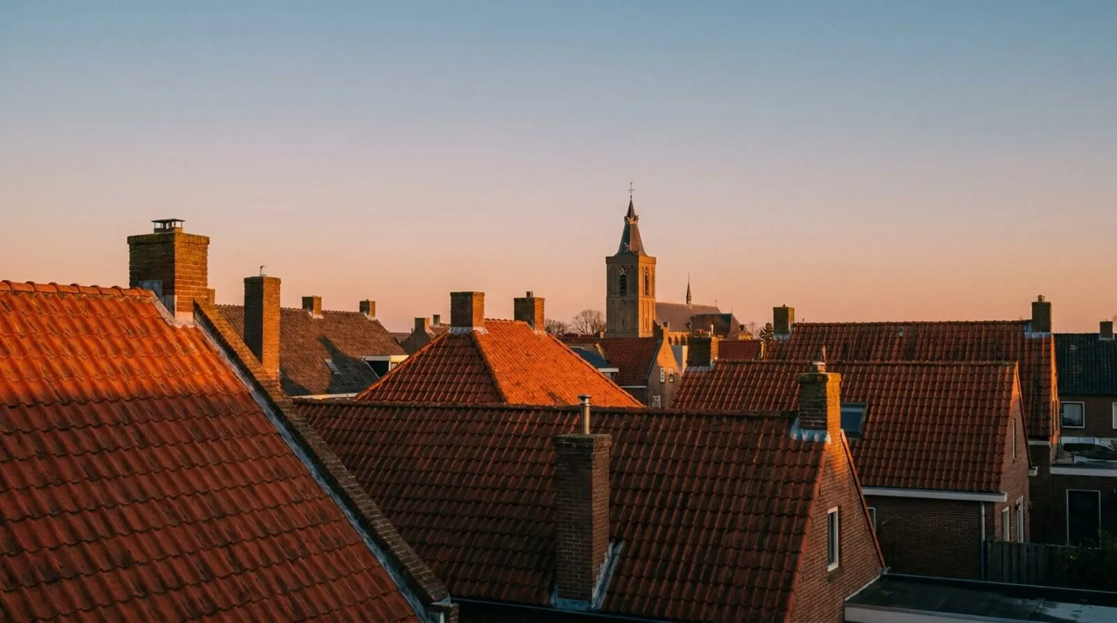 Daken van een dorp in Brabant bij avondlicht