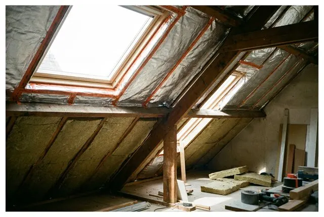 Zolder met isolatiemateriaal tussen de dakspanten en dampremmende folie op de naden