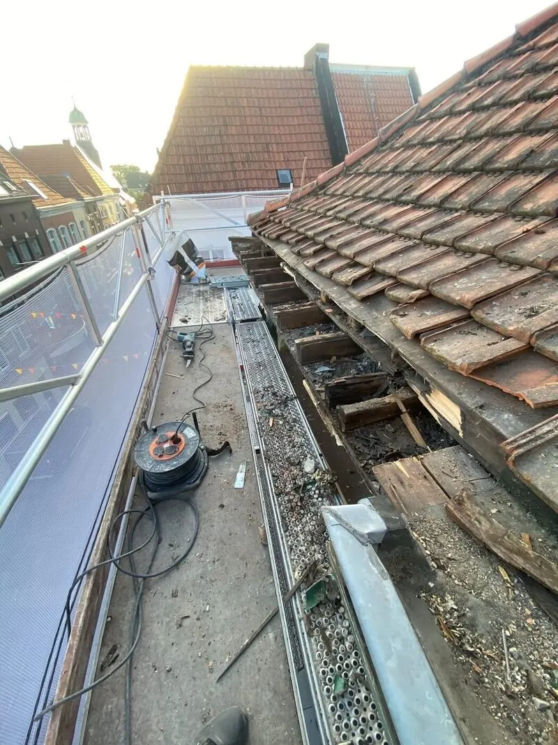 Hellend pannendak in renovatie, opgebouwd vanaf het dakbeschot met een steiger