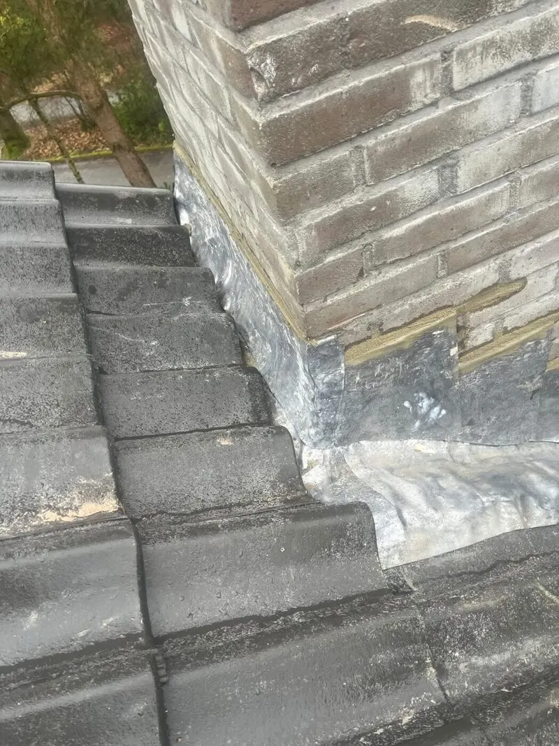 Loodwerk rond een schoorsteen, waterdicht ingewerkt op een dak